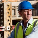 mature man using-laptop on construction site